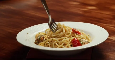 Chef Tasting Spaghetti with cherry tomato slices and salmon pieces simmering in Stock Footage 317561174