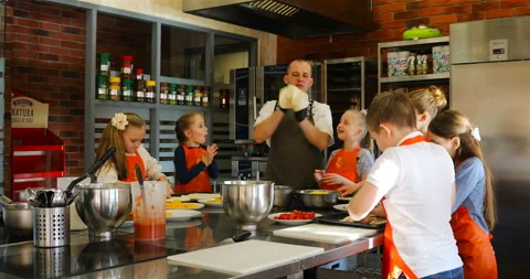 The chef teaches children how to stretch the dough Stock Footage 139539660