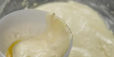 Chef Tempering Egg Yolk with Hot Cream Mixture in Small Ceramic Bowl Stock-Footage 343588328