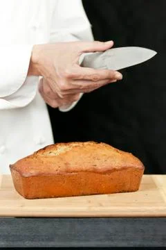 Chef tests knife sharpness over banana bread Stock Photos