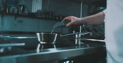 Chef tests temperature of water in pot Stock Footage 204973174