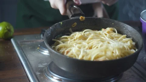 Chef throwing spaghetti pasta in a frying pan in a restaurant kitchen. Stock Footage 124710062