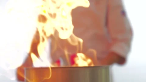 The chef throwing spices in the kitchen fire in slow motion. Stock Footage 141561439