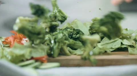 Chef throws broccoli on the table, on a wooden board in lettuce Stock Footage 68722078