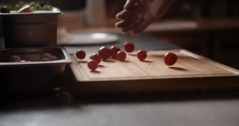 Chef throws cherry tomatoes to the cutting board in slow motion Stock Footage 266924642