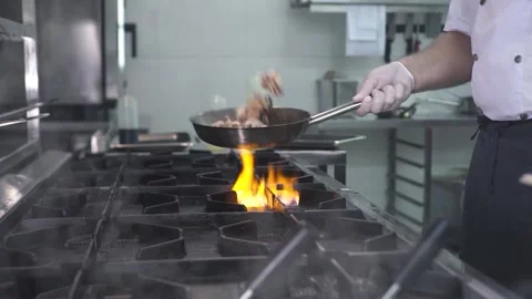 Chef throws up cooking octopuses in frying pan in kitchen Stock Footage 143114320