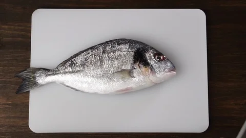Chef throws fresh fish on a cutting board, slow motion. Stock Footage 125247363