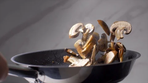 Chef throws mushrooms in a pan 動画素材 103574185