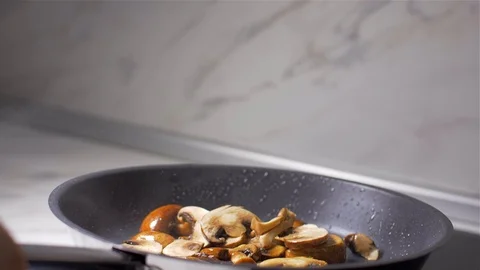 Chef throws mushrooms in a pan Video stock 103574311