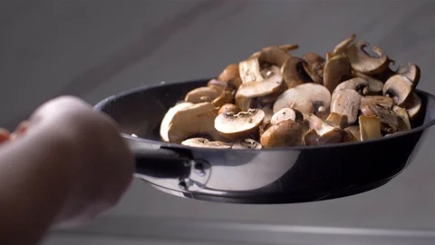 Chef throws mushrooms in a pan 動画素材 103574523