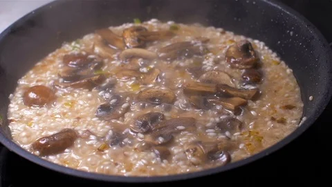 Chef throws the risotto with mushrooms in a pan Stock Footage 103631425
