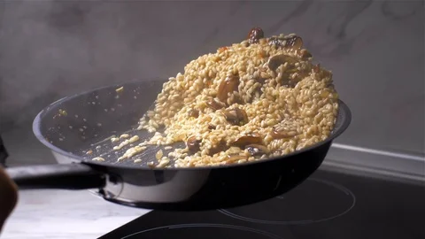 Chef throws the risotto with mushrooms in a pan. slow motion Stock Footage 103631608