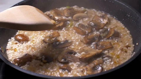 Chef throws the risotto with mushrooms in a pan Stockbeeldmateriaal 103631721