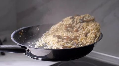 Chef throws the risotto with mushrooms in a pan. slow motion Vídeo Stock 103631919