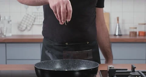 Chef throws rosemary into the steaming frying pan. Adding fresh rosemary herbs Stock Footage 252382750