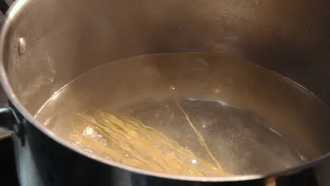The chef throws spaghetti into boiling water Stock Footage 157981700