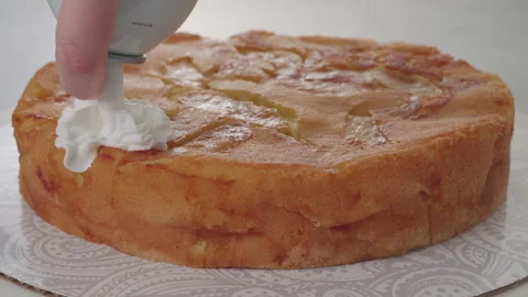 Chef topping apple cake with whipped cream. Stock Footage 265601164