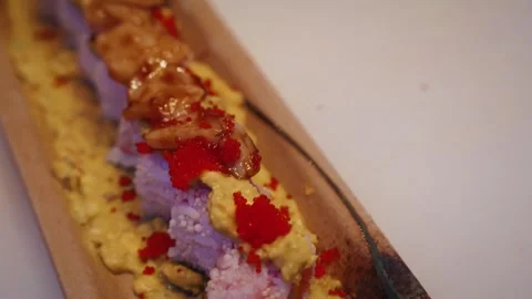 Chef topping scallop on tobiko mango guacamole sushi roll – 4K close up Stock Footage 315565003