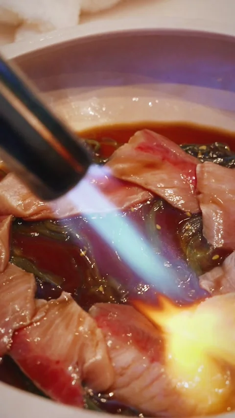 Chef torching snapper sashimi with soy sauce and seaweed 4K vertical video Stock Footage 315990363