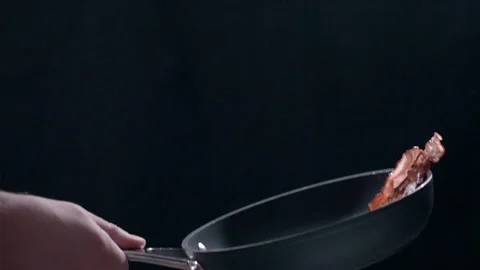 Chef tosses fried bacon on the hot pan Stock Footage 143779954