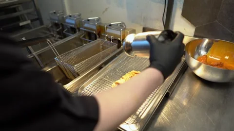 Chef tosses fried chicken wings in vibrant orange buffalo sauce Stock Footage 262554767