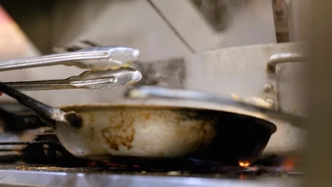 Chef tosses the pan with sauce on the fire Stock-Footage 127600977