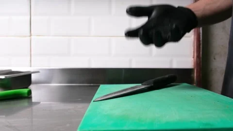The chef tosses pickled cucumbers in the air on a green cutting board. Stock Footage 278348382