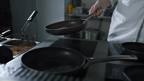 Chef tosses roasting beef on the hot pan at the restaurant kitchen in slow Stock Footage 106292406