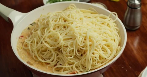 A chef tosses a tomato-spinach-cream sauce with seared salmon and flips it with Stock Footage 318572753