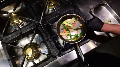 Chef tossing and sauting mixed vegetables in a pan Stock Footage 327255304