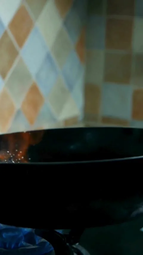 Chef tossing fresh vegetables in hot wok over flame Video stock 331935429