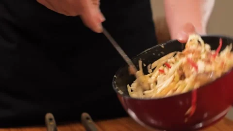 Chef Tossing Freshly Cooked Asian Stir-Fry Noodles in a Bowl Stock Footage 333600211