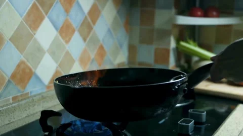 Chef tossing mixed vegetables in wok over high flame Stock Footage 332278348
