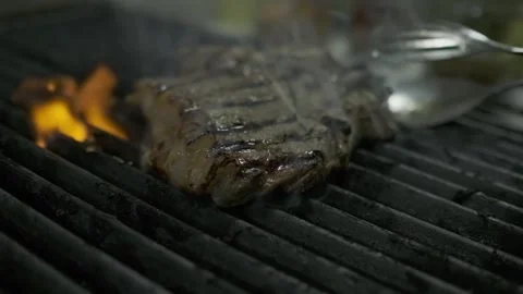 The chef touches and flips pieces of grilled meat steak Stock Footage 252667041