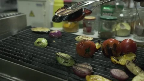 The chef transfers the roasted vegetables from the grill to a large container Stock Footage 245872910