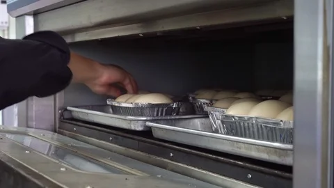 Chef with a tray of bread dough into the oven. Stock Footage 115353127