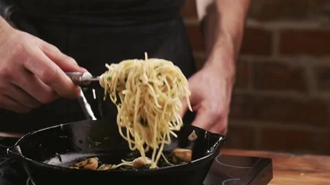 Chef trying to serving cooked pasta. Pasta fall down to a frying pan again. Video stock 151140902