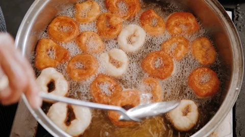 Chef turn over crispy donuts that are fried in pan with hot boiling oil Video stock 111461554