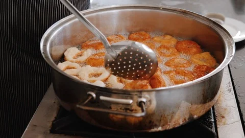 Chef turn over with ladle crispy donuts that are fried in pan Stock Footage 111461270