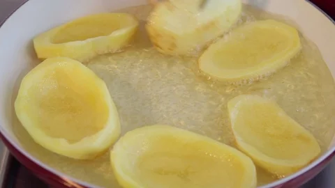 Chef turning big potato sliced chips frying in ceramic pan. Boiling oil. Stock Footage 71124298