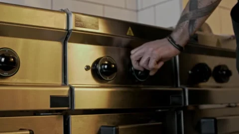Chef turning the control knob of an industrial stainless steel deep fryer 動画素材 315231678