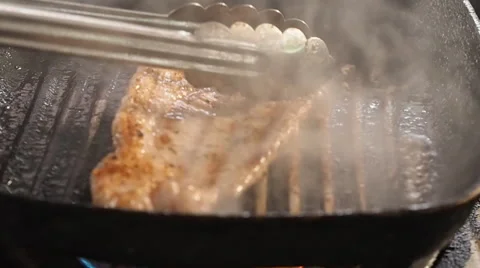 Chef turning thick juicy rib-eye steaks on hot grill Vidéo 64231015