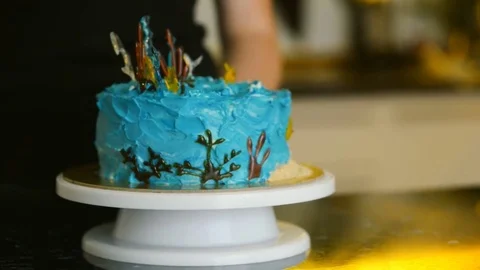 Chef turns cake standing on stand in kitchen of restaurant indoors. Stock Footage 81158914