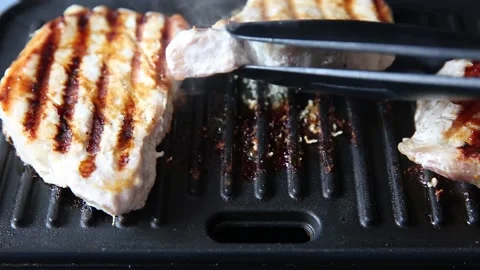 The chef turns the grilled meat over on the grill. Stock Footage 152770133