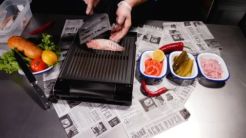 The chef turns half of the mackerel fillet. In safe gloves. Stock Footage 128291277