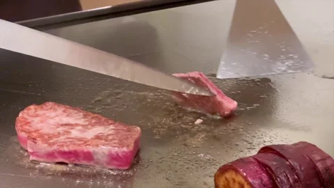 Chef turns Kobe A5 beef on teppan grill in Japan Stock Footage 324021037
