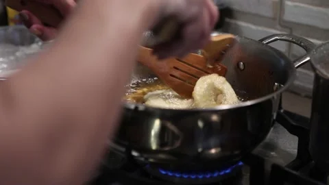 Chef turns over the Apples in the dough, fried in pan in boiling oil Stock Footage 167196330