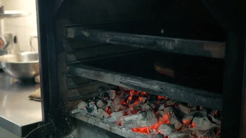 The chef turns over to the other side a piece of baked meat in a restaurant Stock Footage 92938093