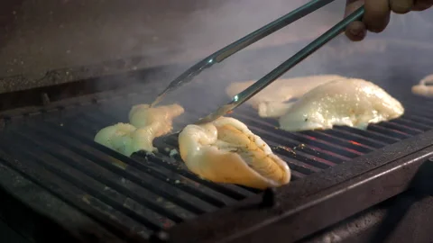 Chef turns squid in the grill using special tongs close up Stock-Footage 152649561