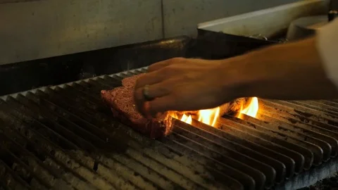 Chef turns steak on flame grill and pushes on it Stock-Footage 94247740